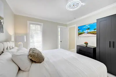 a white bedroom with a large white bed and a window at Breathtaking 5BR & 3BA Villa near Hollywood Beach in Hollywood