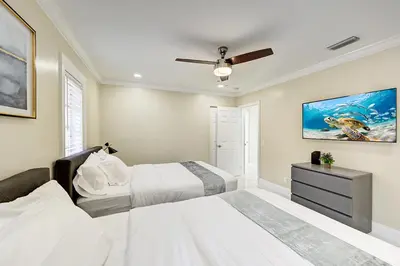 a bedroom with two beds and a ceiling fan at Breathtaking 5BR & 3BA Villa near Hollywood Beach in Hollywood