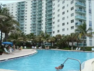 a person in a swimming pool in a resort at Komffy Apt w/2 Queen Beds & Canal View at Tides in Hollywood