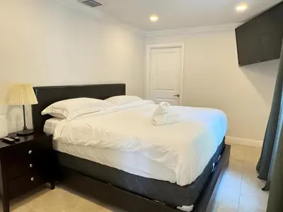 a bedroom with a large bed with white sheets at Spacious 4/4 Home Central To All Attractions in Hollywood