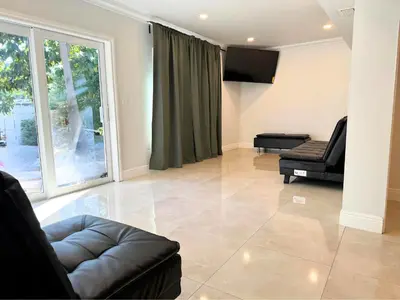 a living room with a couch and a large window at Spacious 4/4 Home Central To All Attractions in Hollywood