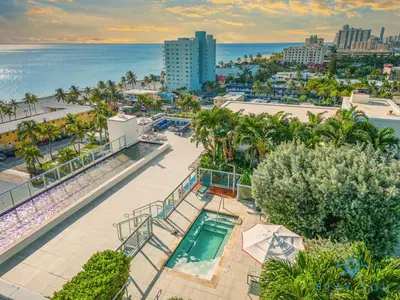 an aerial view of a resort with a swimming pool and the ocean at Studio - Steps from Hollywood Boardwalk in Hollywood