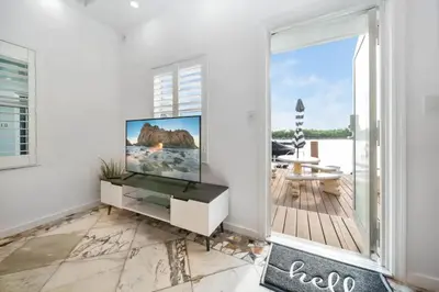 a living room with a flat screen tv on a white wall at Waterside Escape w/Queen Bed & Free Parking in Hollywood