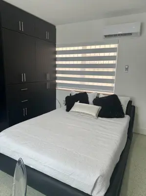 a bedroom with a large bed with black cabinets at VillaClara Studio-Little Havana in Miami