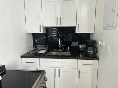 a kitchen with white cabinets and a sink at VillaClara Studio-Little Havana in Miami