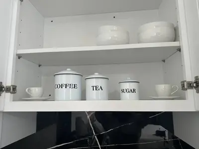 a white cabinet with cups and dishes in it at VillaClara Studio-Little Havana in Miami