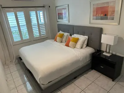 a bedroom with a bed with white sheets and pillows at Komffy Intercoastal retreat King Bed, Free Parking in Hollywood