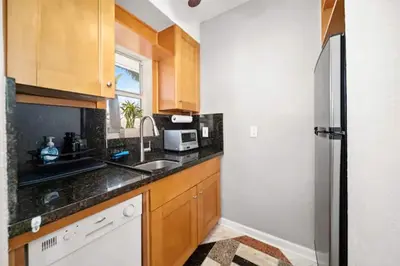 a kitchen with wooden cabinets and a stainless steel refrigerator at Komffy Intercoastal retreat King Bed, Free Parking in Hollywood