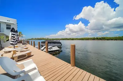 a dock with chairs and a boat on the water at Komffy Intercoastal retreat King Bed, Free Parking in Hollywood