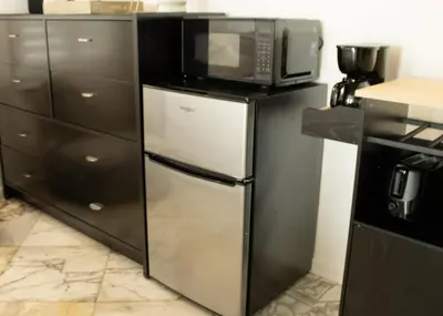 a microwave sitting on top of a refrigerator in a kitchen at Komffy Studio with King Bed in Hollywood