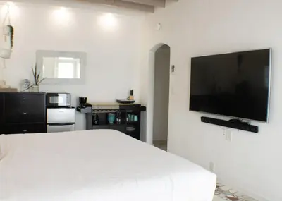 a bedroom with a white bed and a flat screen tv at Komffy Studio with King Bed in Hollywood
