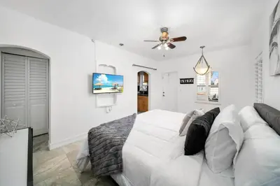 a white bedroom with a bed and a ceiling fan at Waterside Studio w/ King bed - Hollywood in Hollywood