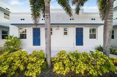 a white house with blue doors and palm trees at Waterside Studio w/ King bed - Hollywood in Hollywood