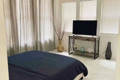a bedroom with a bed and a flat screen tv at Brickell + Wynwood Wonderland: Spacious 6BR Home in Miami