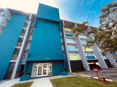 a blue building with palm trees in front of it at 1BR with Kitchen Close To Sunny Isles Beach in North Miami Beach