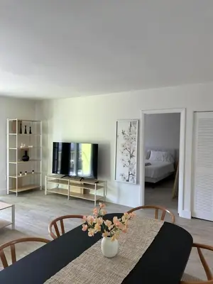 a living room with a table and chairs and a television at 1BR with Kitchen Close To Sunny Isles Beach in North Miami Beach