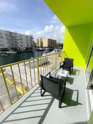 two chairs and a table on a balcony overlooking the water at 1BR with Kitchen Close To Sunny Isles Beach in North Miami Beach