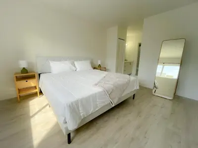 a bedroom with a large white bed and a mirror at 1BR with Kitchen Close To Sunny Isles Beach in North Miami Beach