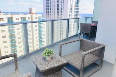 a balcony with two chairs and a table with a plant at Luxury 2 Bedroom Ocean View en Hyde Resort in Hollywood