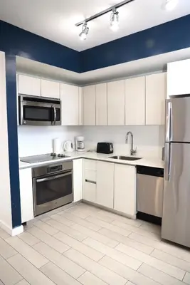 a kitchen with white cabinets and stainless steel appliances at 2BR-2BA Oasis W-Stunning Views at Beachwalk in Hallandale Beach
