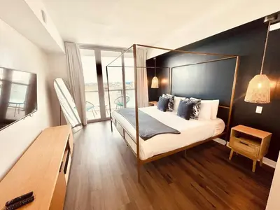 a bedroom with a canopy bed and a balcony at Beachwalk -1 Bedroom W-Kitchen and Great Views in Hallandale Beach