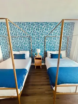 two beds in a room with blue and white wallpaper at Beachwalk Studio W-Kitchenette Beach Pool Gym in Hallandale Beach