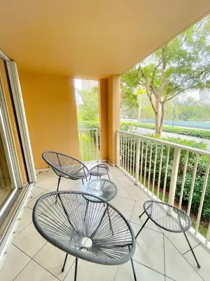 two chairs and two tables on a balcony at 2 Luxury Bedrooms at Yacht Club de Aventura in Miami