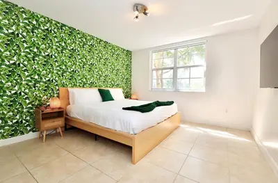 a bedroom with a green wall with a bed at 2 Luxury Bedrooms at Yacht Club de Aventura in Miami