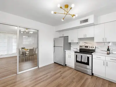 a kitchen with white cabinets and stainless steel appliances at 3BR Newly Renovated In Miami 15 Min To Beach in Miami