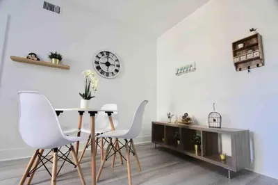 a dining room with a table and white chairs at CHIC AND MODERN APARTMENT STEPS FROM THE BEACH in Miami Beach