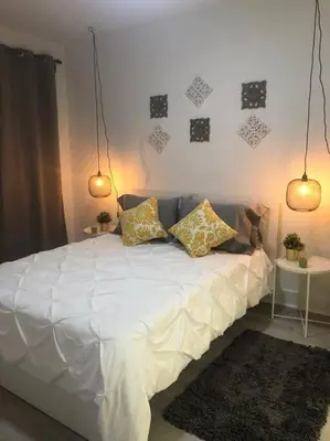 a bedroom with a white bed with pillows on it at CHIC AND MODERN APARTMENT STEPS FROM THE BEACH in Miami Beach
