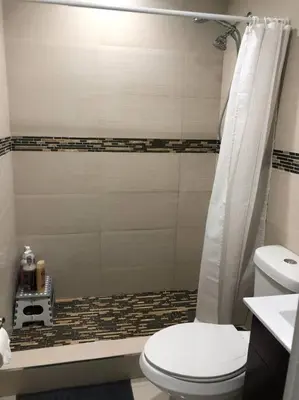 a bathroom with a toilet and a shower at CHIC AND MODERN APARTMENT STEPS FROM THE BEACH in Miami Beach
