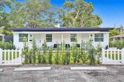 a white house with a white picket fence at Hallandale Beach Modern apartment Chic Backyard in Hallandale Beach