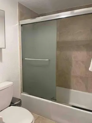 a bathroom with a glass shower door next to a toilet at Ocean view 1 bedroom in Hollywood in Hollywood