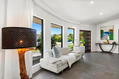a living room with a white couch and windows at Casa Olan - Luxury Family Oasis 3BR North Miami Beach Villa with Saltwater Pool & Canal Views in Miami