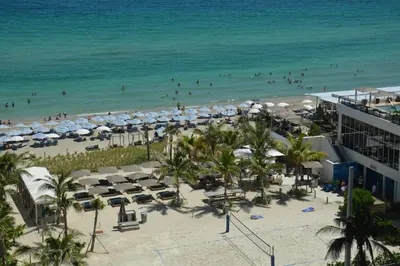 a beach with umbrellas and people on the beach at Amazing apartment by the Ocean in Hollywood
