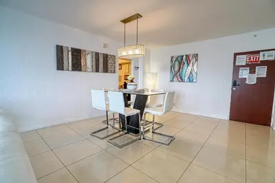 a dining room with a table and white chairs at Amazing apartment by the Ocean in Hollywood