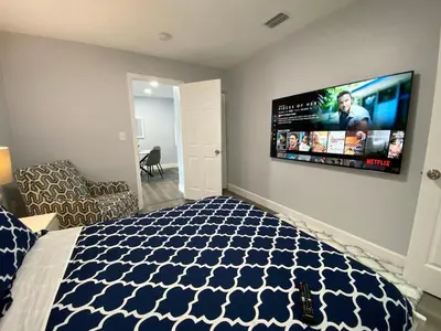 a bedroom with a bed and a flat screen tv on the wall at Rachaels Upscale 3 bedrooms Luxury Home in Fort Lauderdale