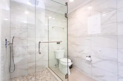 a bathroom with a toilet and a glass shower at Walk to Beach Luxury 5BR & 3BA Villa Hollywood Lakes in Hollywood