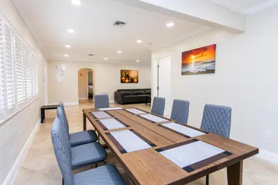 a dining room with a wooden table and chairs at Walk to Beach Luxury 5BR & 3BA Villa Hollywood Lakes in Hollywood