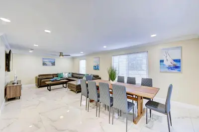 a living room with a table and chairs and a couch at Luxury 5BR & 3BA Villa Walk to Hollywood Beach in Hollywood