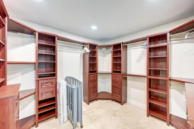 a walk in closet with wooden cabinets and shelves at Luxury 5BR & 3BA Villa Walk to Hollywood Beach in Hollywood