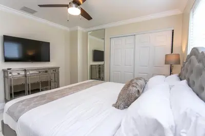 a bedroom with a white bed and a television at Fabulous 5BR & 3BA Villa near Hollywood Beach in Hollywood