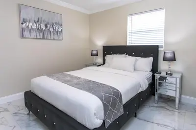 a bedroom with a large bed with white sheets at Fabulous 5BR & 3BA Villa near Hollywood Beach in Hollywood