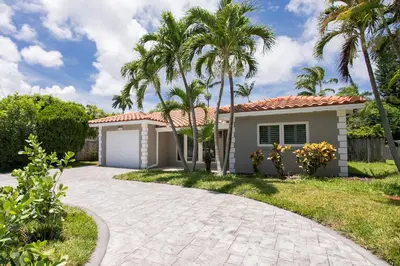 a house with palm trees and a driveway at Fabulous 5BR & 3BA Villa near Hollywood Beach in Hollywood