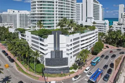 a large building with a statue in the middle of a city at Fontainebleau Miami Beach Junior Suite in Miami Beach
