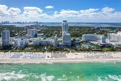 an aerial view of a beach with buildings and the ocean at Fontainebleau Miami Beach Junior Suite in Miami Beach