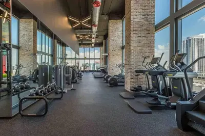 a gym with rows of tread machines and windows at Luxurious Unit in Miami in Miami