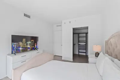 a white bedroom with a bed and a tv at Luxurious Unit in Miami in Miami