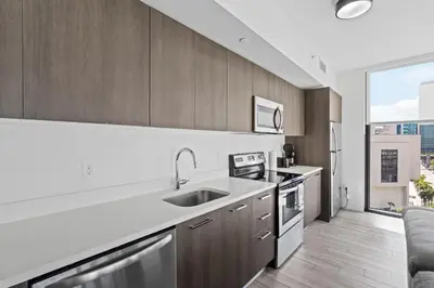 a kitchen with wooden cabinets and a large window at Sublime property in the heart of downtown Miami in Miami